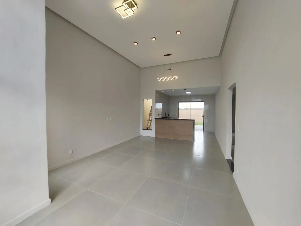 Sala com pé-direito alto e cozinha integrada